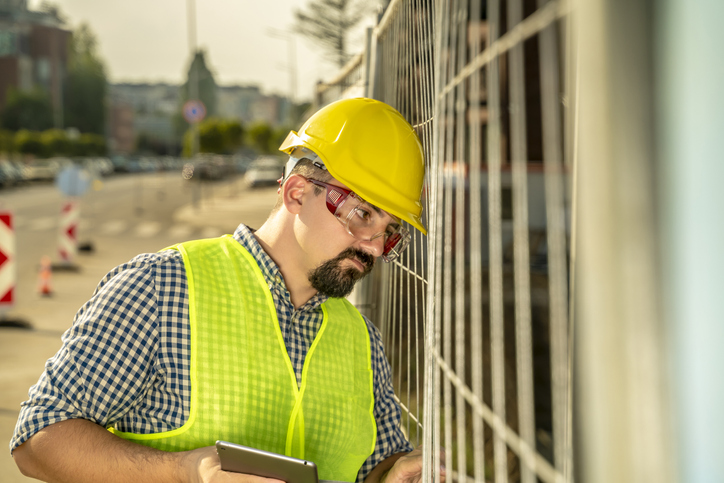 Exhausted engineer, construction worker or architect. The scene is situated outdoors in Sofia city industrial financial area during sunny summer day. The picture is taken with Sony A7III camera.